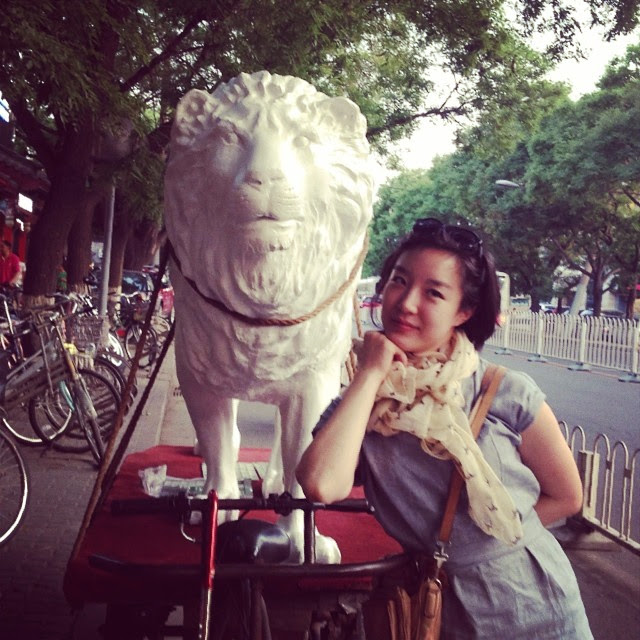 lion hitched to bicycle with pretty girl