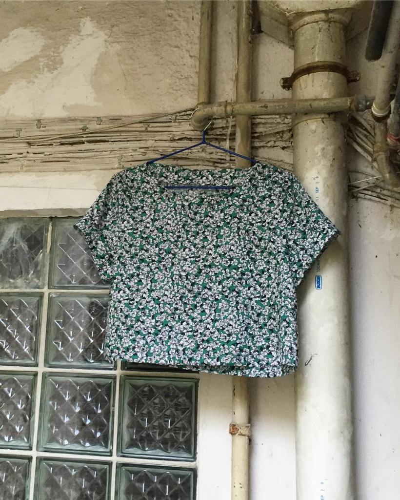 Inari Crop Tee hanging on a hanger